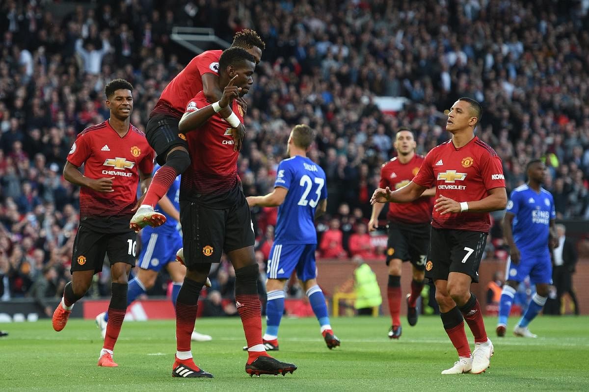 DELIGHTED: Manchester United's Paul Pogba (centre) celebrates with team-mates  Fred (left) and Alexis Sanchez after scoring the opening goal. AFP  