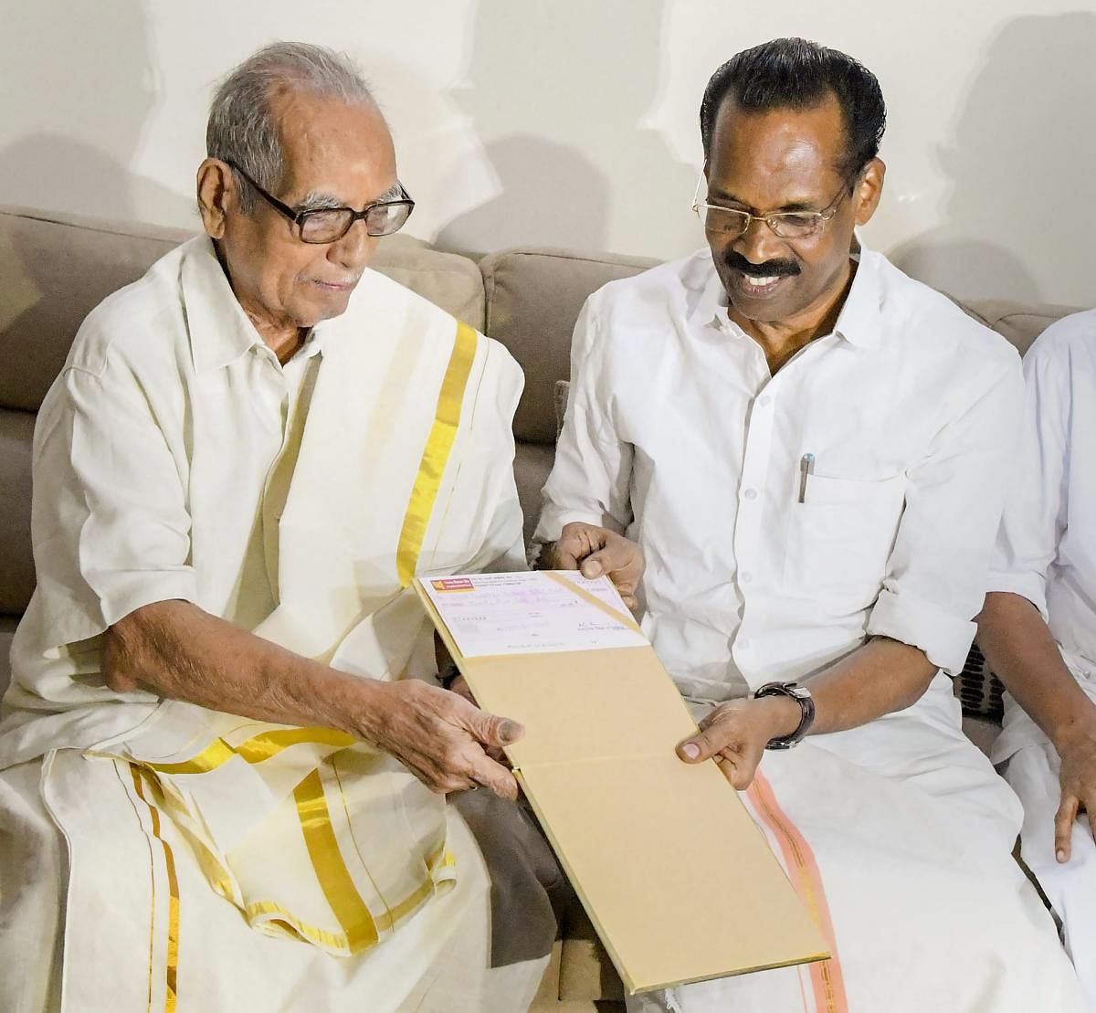 The Zamorin of Calicut, K C Unni Anjan Raja, hands over a cheque of Rs 25 lakh to Kerala Minister T P Ramakrishnan towards the flood relief fund, in Kozhikode on Monday. (PTI Photo)