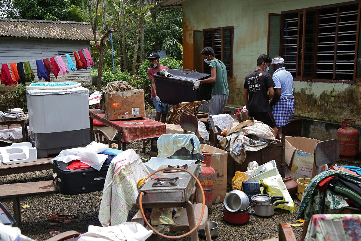 Volunteers collect household items in the lawns of a residential house before cleaning the house following floods in Kuttanad in Alappuzha district, Kerala. Reuters Photo