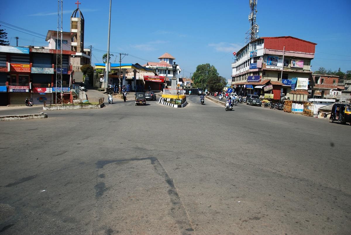calm and the noise: Without private buses and autos, the busy General Thimmaiah Circle in Madikeri wore a deserted look on Saturday. (Right) Elected representatives from the BJP and Congress engage in arguments before the Tipu Jayanti in the town. dh phot