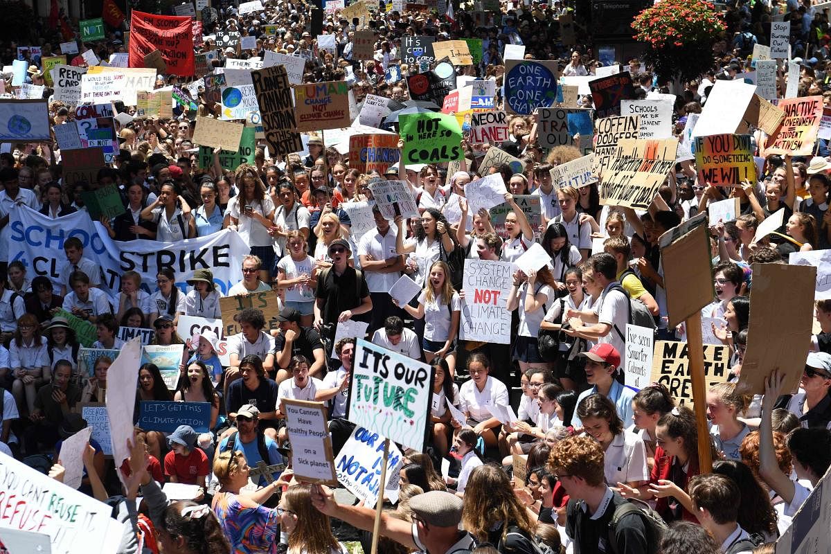 Students from different schools raise placards during a protest rally for climate change awareness at Martin Place in Sydney on November 30, 2018. - Thousands of students around the country skipped school today to protest and demand their politicians act. (AFP Photo)