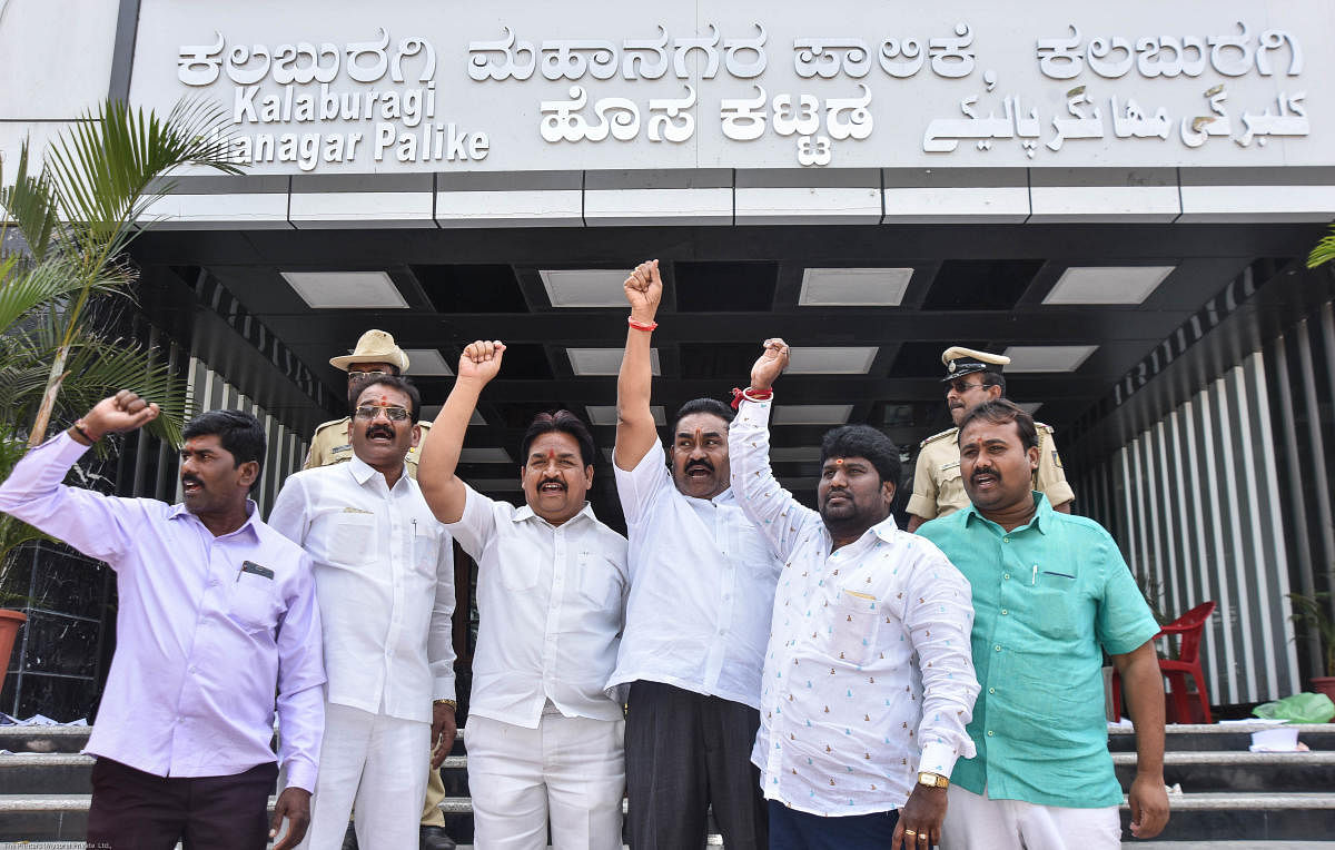 Corporators stage a protest in front of Kalaburagi Mahanagara Palike on Saturday against including Urdu on Palike's name board. DH PHOTO