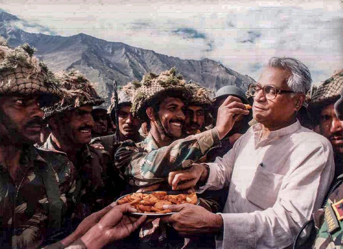 In this undated file photo, then defence minister George Fernandes shares snacks with the Army personnel during a visit to Ganasok in the Batalik Sector, J &amp; K. (PTI file photo)