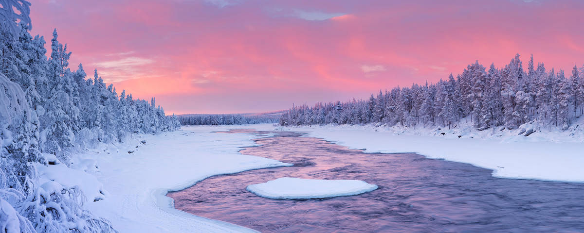 A rapid in a river in a wintry landscape. Photographed at the Äijäkoski rapids in the Muonionjoki river in Finnish Lapland at sunrise.  (Images of Tourism, travel)