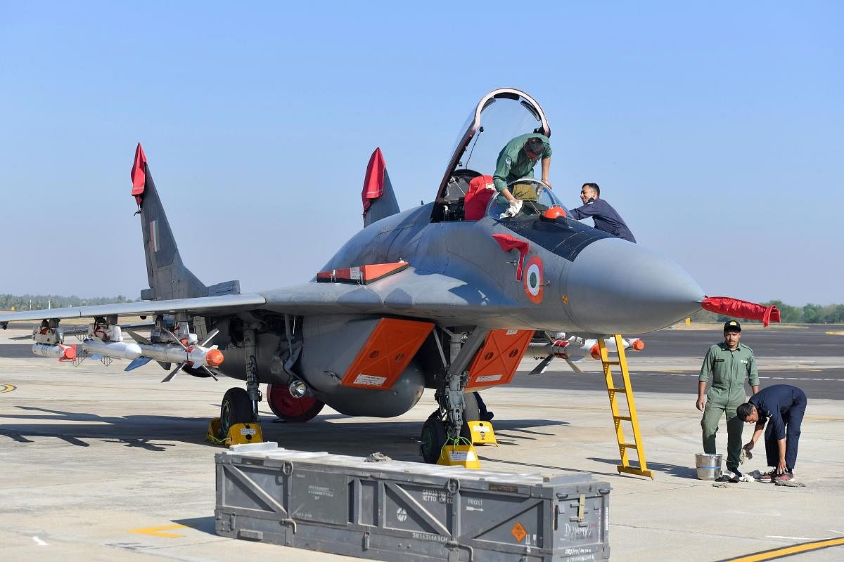 Indian Air Force (IAF) personnel clean a Russian-made MiG-29 fighter aircraft parked at the Yelahanka Air Force Station in Bengalore on February 18, 2019, ahead of the 12th edition of India's biennial international Air Show. - Three Rafale fighters partic