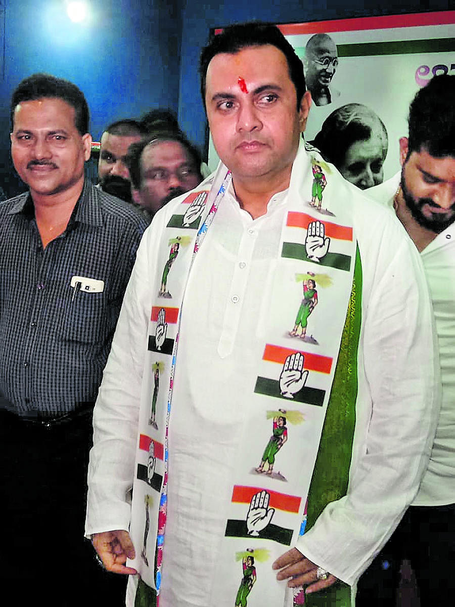 Congress-JD(S) coalition candidate for Udupi-Chikmagalur constituency Pramod Madhwaraj appears wearing a shawl with symbols of both the parties in Udupi on Friday.