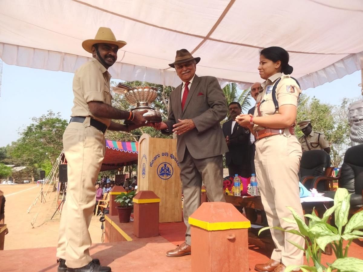 Former Air Marshal K C Cariappa presents the Field Marshal K M Cariappa Trophy to Siddapur police station constable K A Siddartha during the state Police Flag Day programme at the district police grounds in Madikeri on Tuesday.