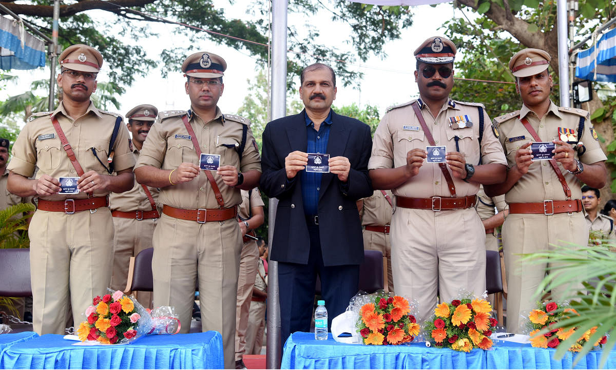 Retired police officer Uday Nayak releases Police Flag Day sticker at the Police Flag Day and Welfare Day programme at the police grounds in Mangaluru on Tuesday.