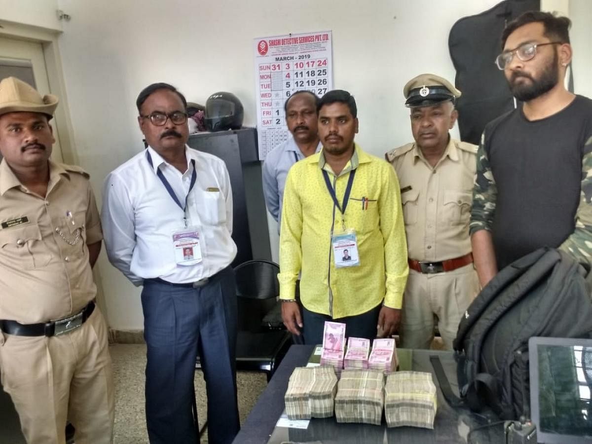 Rahul (right) and the cash seized from him. 