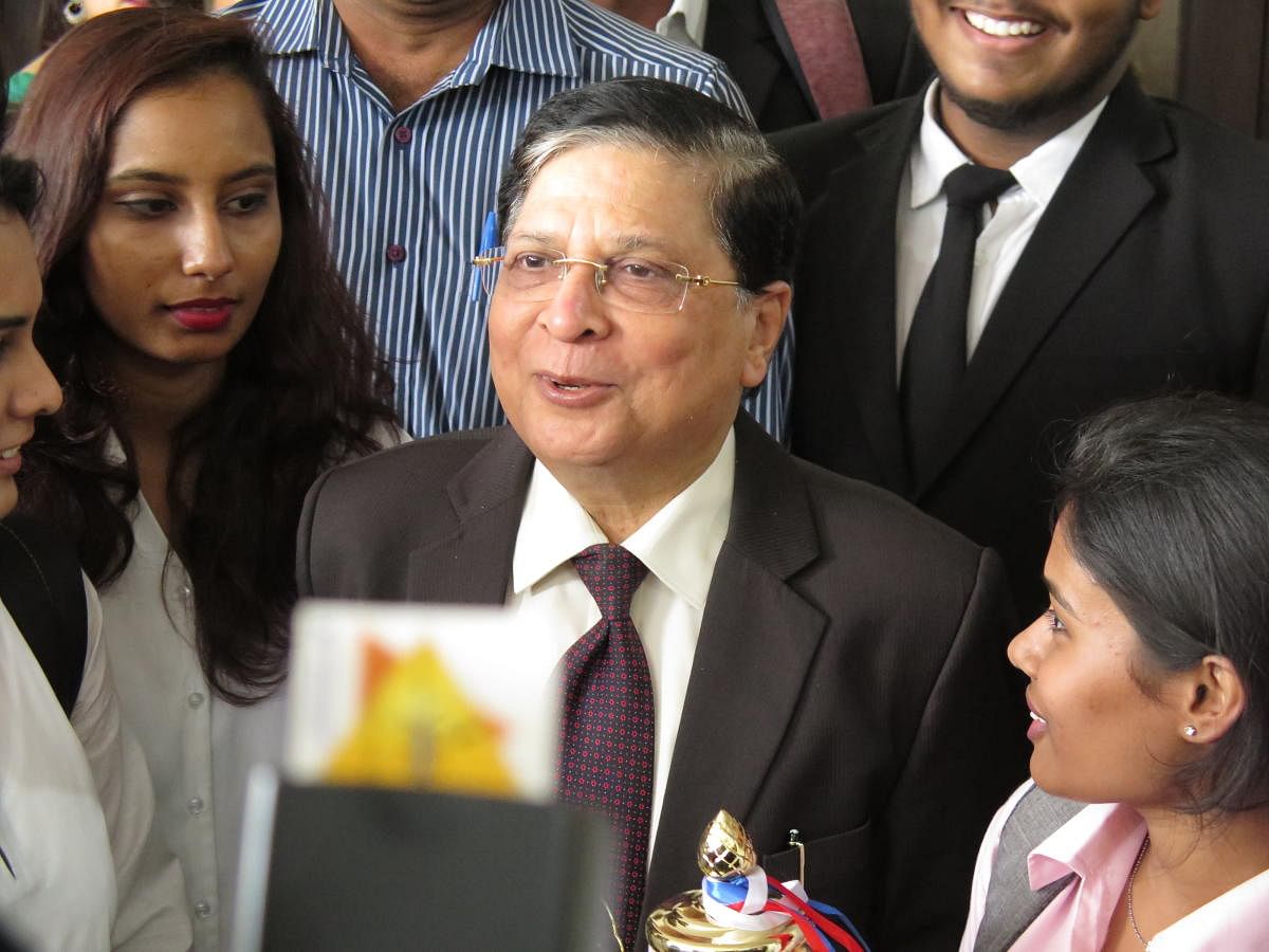 Former Chief Justice of India, Dipak Misra, stands with students at the KLE Law College in Bengaluru on Monday, April 8, 2019.