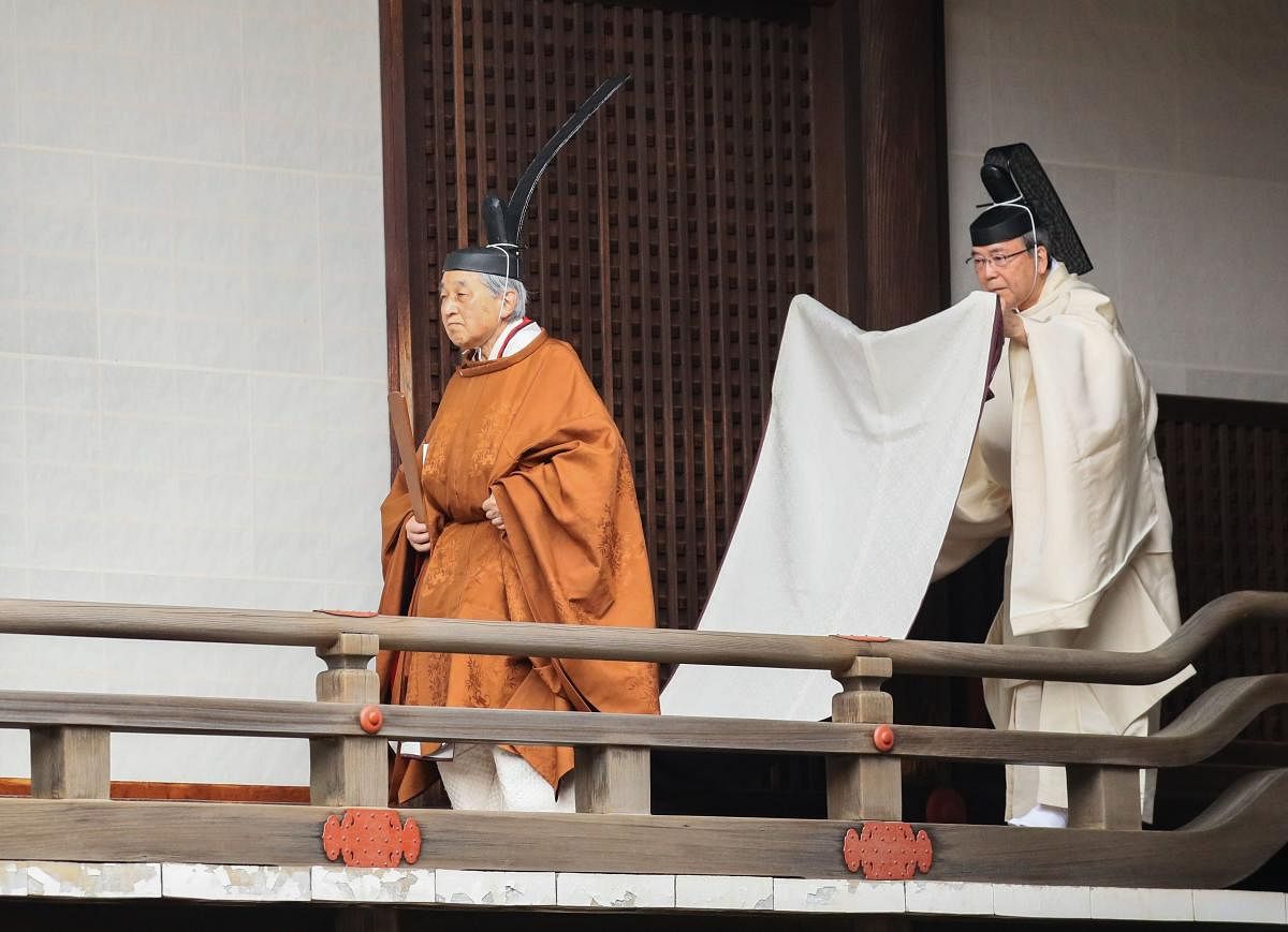 Japan’s Emperor Akihito (L) walks to the Kashikodokoro imperial sanctuary inside the Imperial Palace to attend a ritual to report the conduct of his abdication ceremony in Tokyo. AFP/Japan Pool