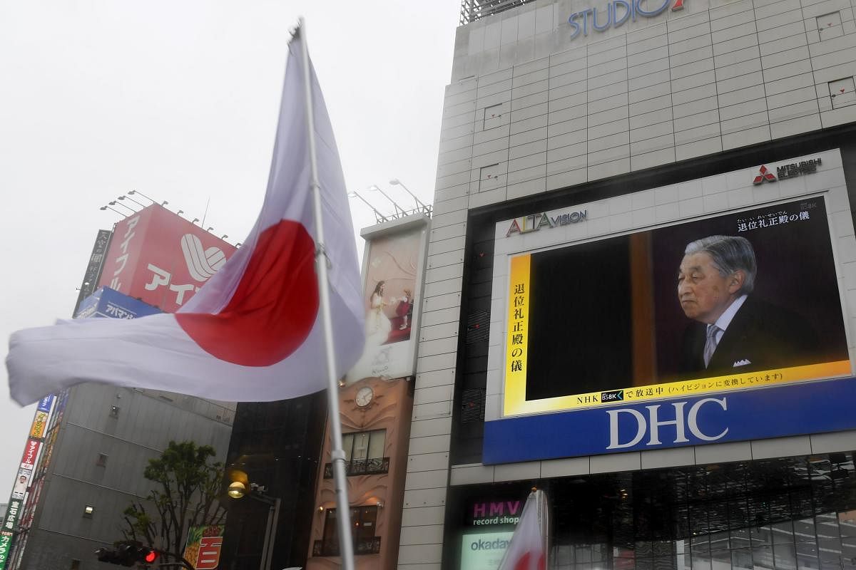 The Japan national flag is seen during a live broadcast of Japan's Emperor Akihito's abdication ceremony on a screen in Tokyo on April 30, 2019. AFP