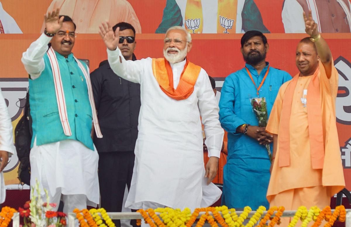 Bhadohi: Prime Minister Narendra Modi with UP Chief Minister Yogi Adityanath and Dy CM Keshav Prasad Maurya waves at the crowd during an election campaign rally for the Lok Sabha polls, in Bhadohi, Sunday, May 5, 2019. (PTI Photo)