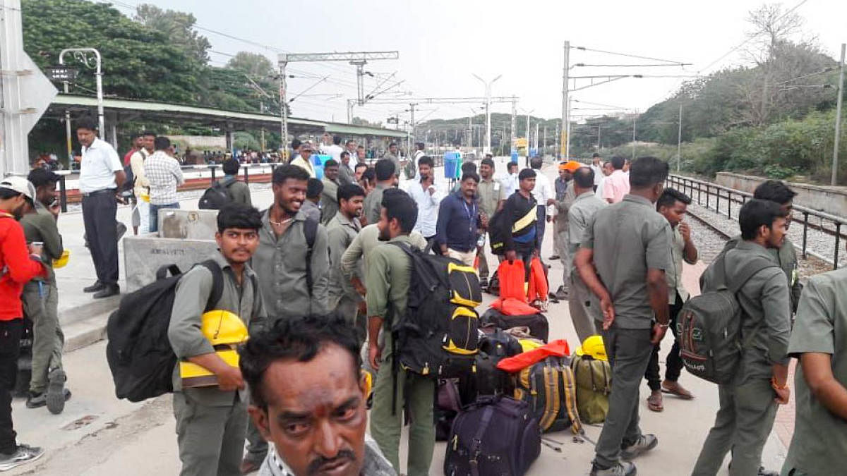 Bescom staff wait for the Odisha train at the Bengaluru Cantonment railway station on Monday. DH PHOTO