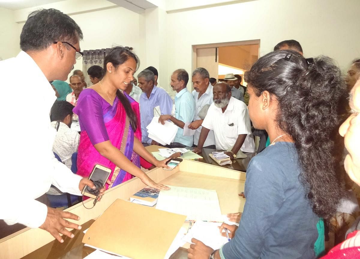 Kodagu Deputy Commissioner Annies Kanmani Joy checks the applications received during the Parihara Adalat in Madikeri on Monday.