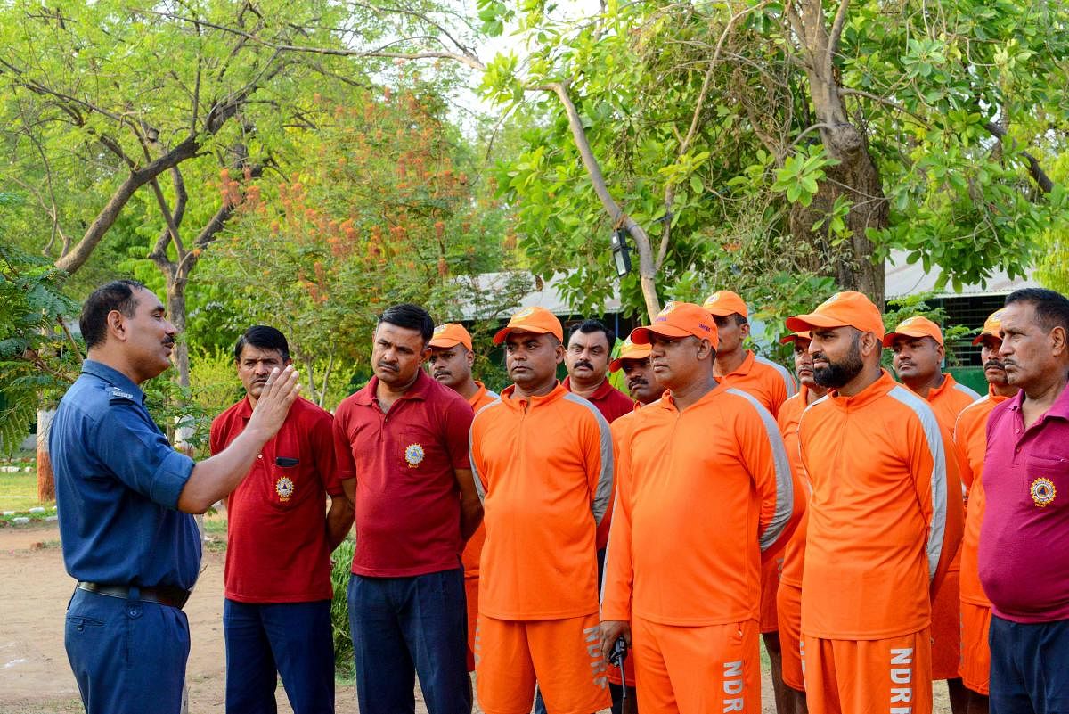 Deputy Commandant at India's 6th National Disaster Response Force (NDRF), Ranvijay Kumar (L), briefs NDRF personnel at an NDRF camp in Chiloda (also called Naroda), some 40 kms from Ahmedabad. (AFP Photo)