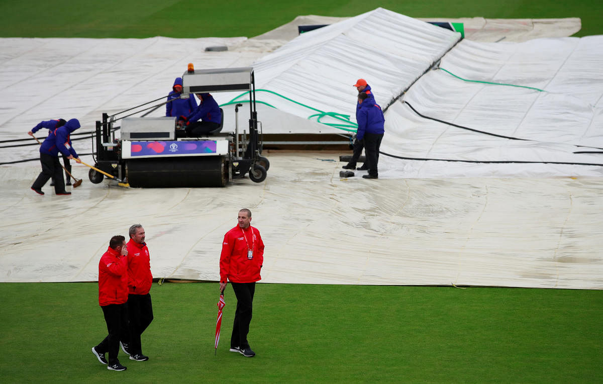 Umpires (in red) inspect the pitch during a rain delay before deciding to call off the match between Sri Lanka and Bangladesh on Tuesday. Reuters