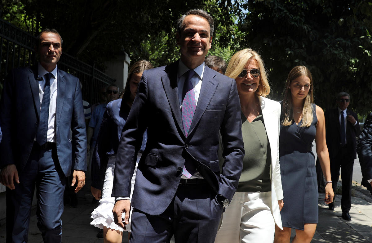 Kyriakos Mitsotakis, along with his wife Mareva Grabowski-Mitsotakis, arrives for a swearing-in ceremony as prime minister near the Presidential Palace in Athens (Reuters Photo)