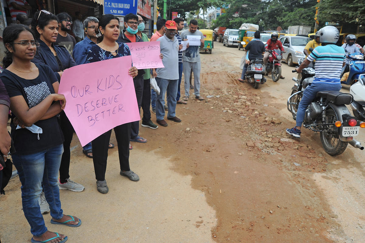 Residents of Horamavu, Kalkere protest demanding good roads and civic amenities at Jayanthi Circle in front of BBMP office in Bengaluru on Saturday. Residents came in large numbers to protest as the main roads are in bad conditions for several weeks causing traffic jam and accidents in the area. | DH Photo: Pushkar V