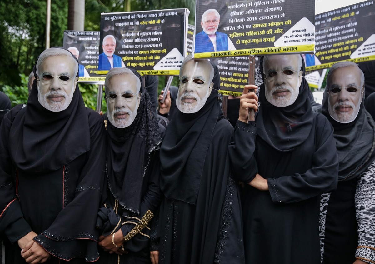 Muslim women wearing face masks of Indian Prime Minister Narendra Modi take part in an event to celebrate the passage of a law to outlaw Triple Talaq in Bhopal (AFP Photo)