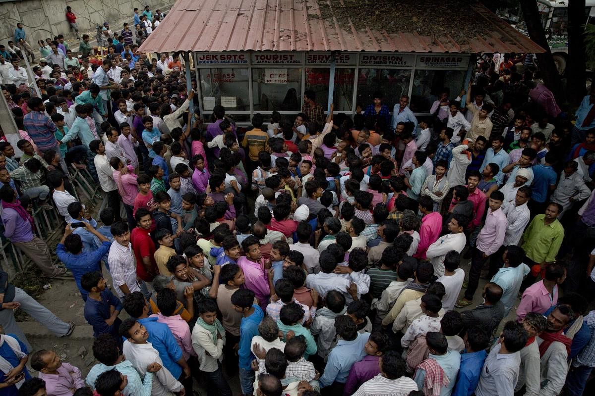 Migrant workers crowd outside the government transport yard to buy bus tickets to leave the region, during curfew in Srinagar. (AP/PTI File Photo)