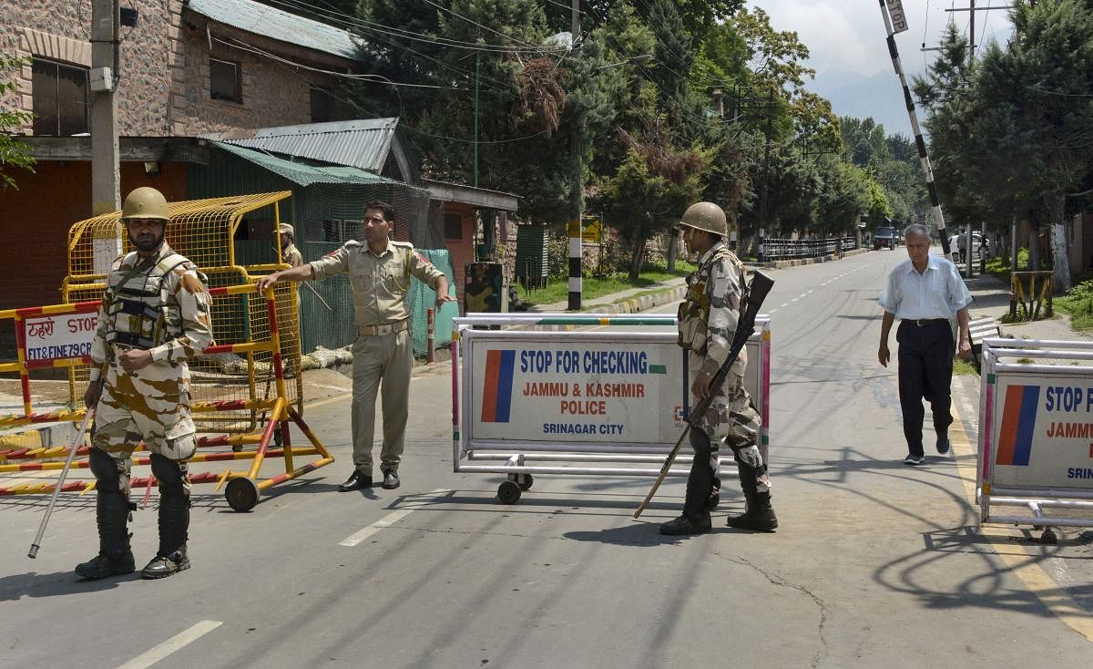 Security personnel stand guard as they block a road leading to the residence of Farooq Abdullah, Omar Abdullah and Mehbooba Mufti during restrictions in Srinagar. (PTI Photo)