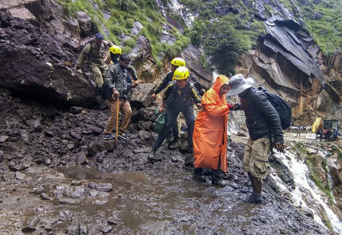 State Disaster Response Force (SDRF) team helps pilgrims cross damaged path on the route of Kailash Mansarovar Yatra, in Pithoragarh district  (PTI Photo)