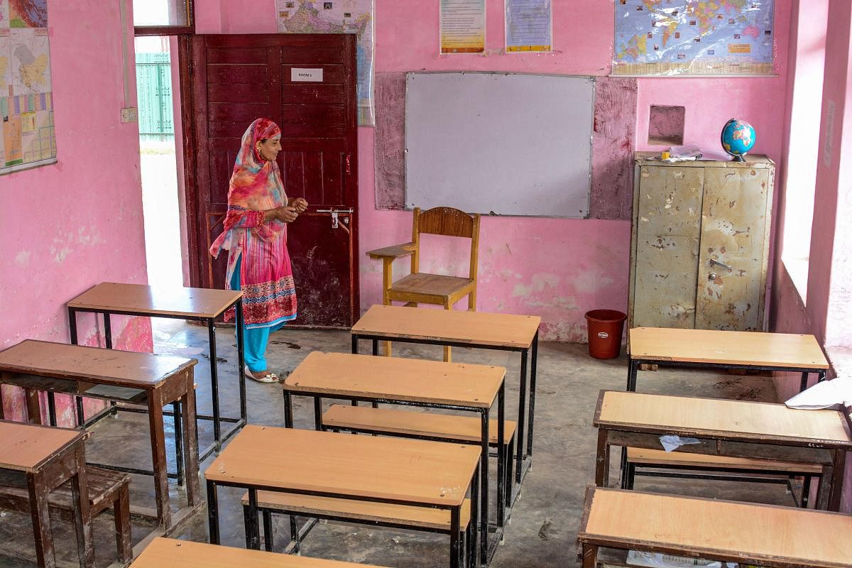A government school employee inspects a classroom in Srinagar, Monday, Aug. 19, 2019. Teachers and staffs reportedly showed up in most of the schools but students didn't as parents were apprehensive about the security situation in view of violent protests