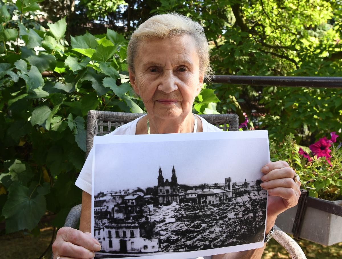 Zofia Burchacinska, an eyewitness to the bombing of Wielun holds a picture of the destroyed town on August 20, 2019. (Photo by Janek SKARZYNSKI / AFP)