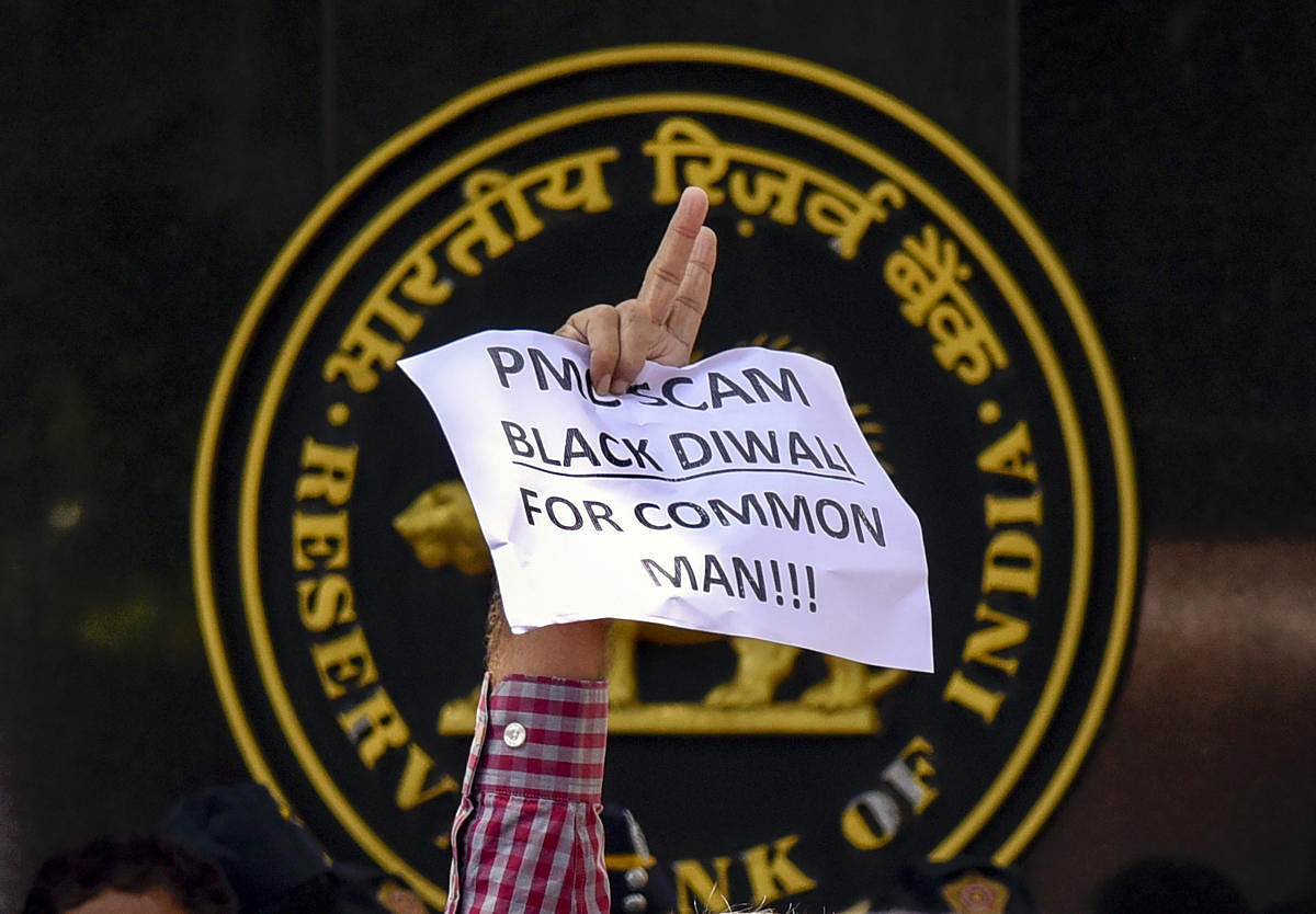 A depositor of Punjab and Maharashtra Cooperative (PMC) bank displays a placard during a protest over the bank's crisis, outside the Reserve Bank of India building, in Mumbai. (PTI Photo)