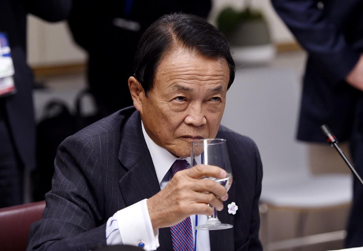 Japan's Finance Minister Taro Aso looks drinks water during a meeting between the Finance Ministers and Central Bank Governors of the G7 nations during the IMF and World Bank Fall Meetings in Washington, DC. AFP