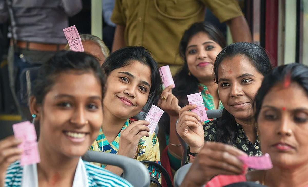 Women passengers show their 'pink tickets' while travelling by a DTC bus in New Delhi on Tuesday. (PTI Photo)