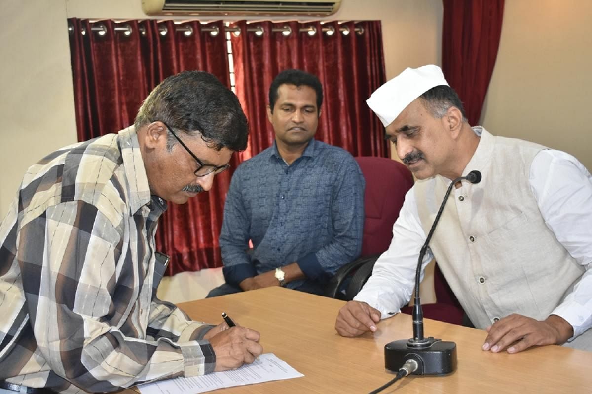 Independent candidate Rajendra Kumar, who is contesting from Kadri South ward, signs an affidavit promising the formation of a ward committee and area sabhas if elected, at a press conference at Press Club in Mangaluru on Monday.