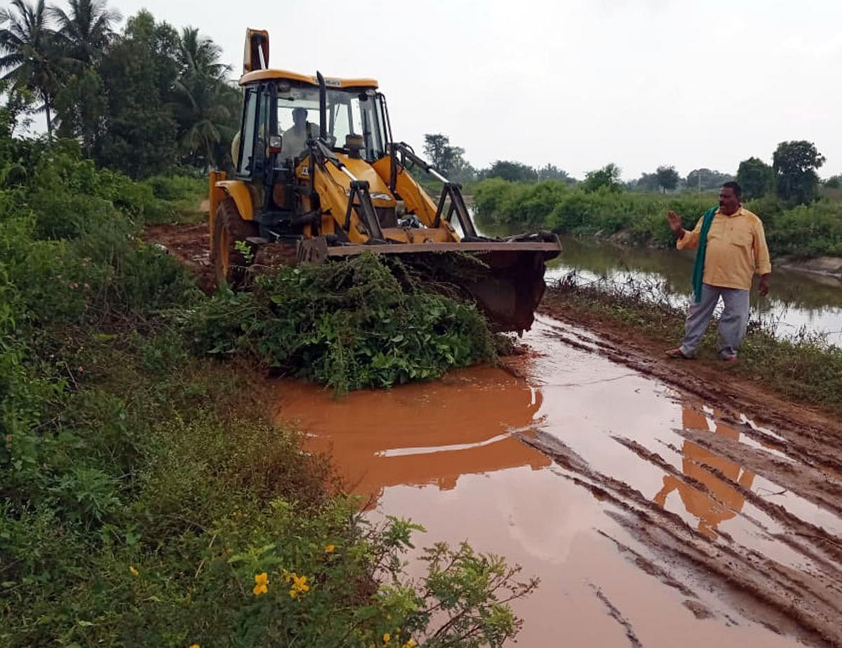 The road connecting Doddapalaya and Allapattana being repaired with an excavator rented by farmer Jayaramegowda in Srirangapatna taluk of Mandya district.