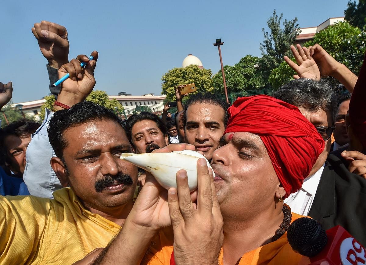 Hindu Mahasabha leader Swami Chakrapani blows a conchshell as they celebrate the Supreme Court's verdict on Ayodhya land case, in New Delhi, Saturday, Nov. 9, 2019. (PTI Photo)