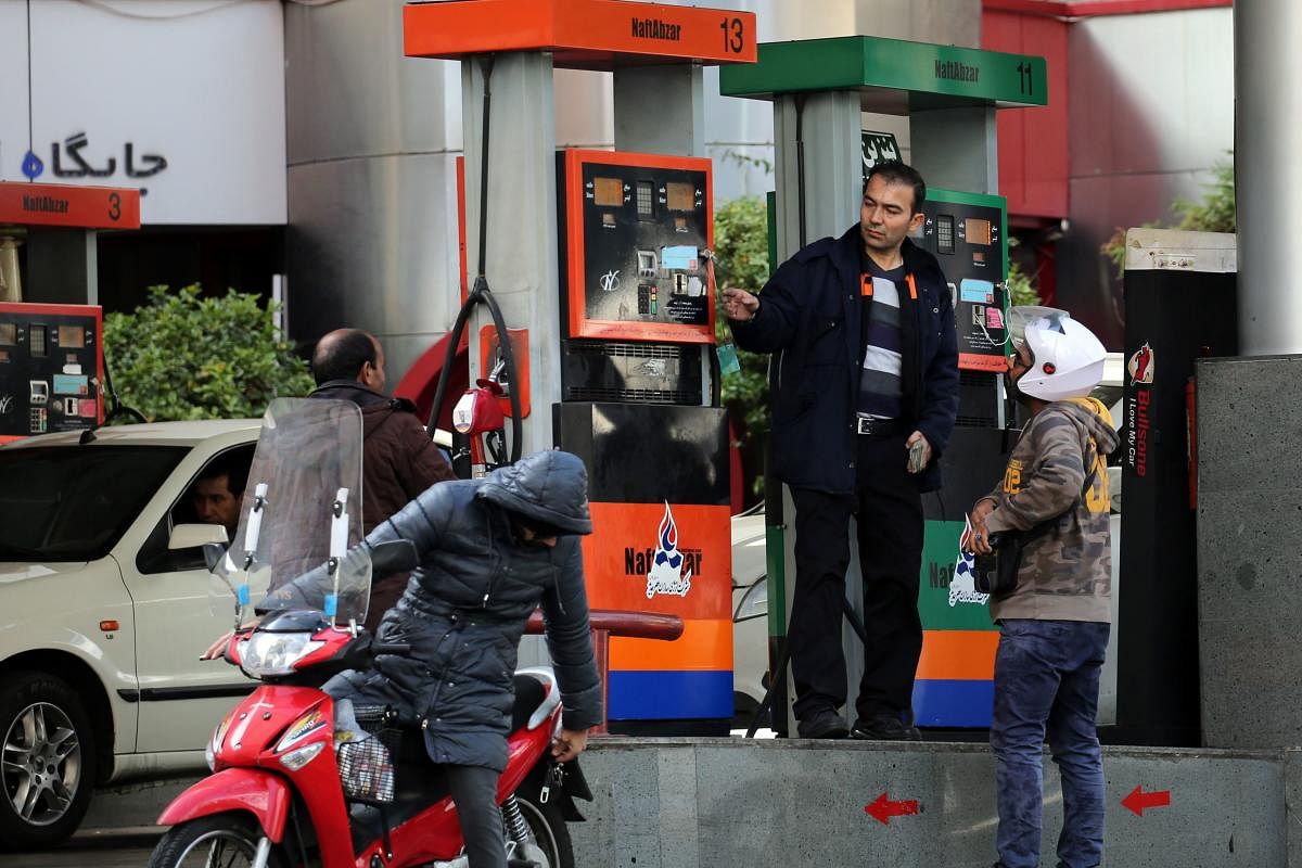 Iranians fill their vehicles at a petrol station in Tehran. (Photo by AFP)