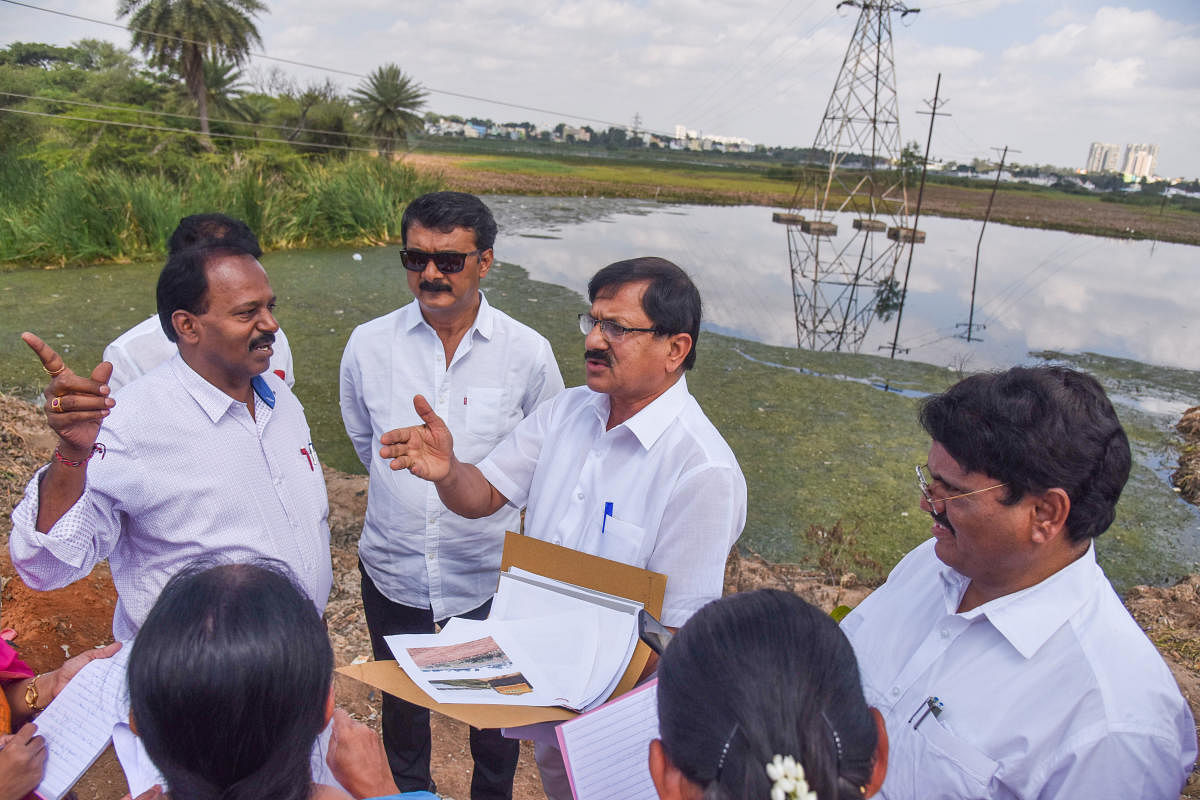 Araga Jnanendra, panel chairman, along with officials inspect the Yele Mallappa Shetty Lake on Thursday. DH Photo/S K Dinesh