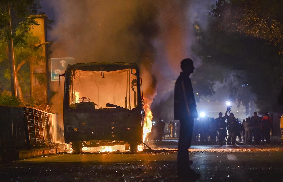 New Delhi: A bus set ablaze by protestors against the Citizenship Amendment Act at Mathura Road, in New Delhi, Sunday, Dec. 15, 2019. (PTI Photo)
