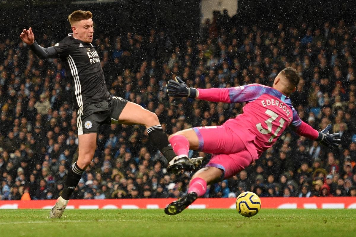 Leicester City's English midfielder Harvey Barnes tries to reach a cross as Manchester City's Brazilian goalkeeper Ederson (R) tries to block during the English Premier League football match between Manchester City and Leicester City at the Etihad Stadium