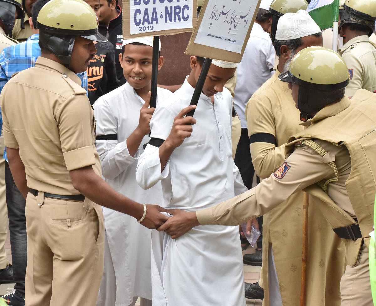 Policemen frisk young boys participating in the rally on Monday. DH PHOTO/JANARDHAN B K