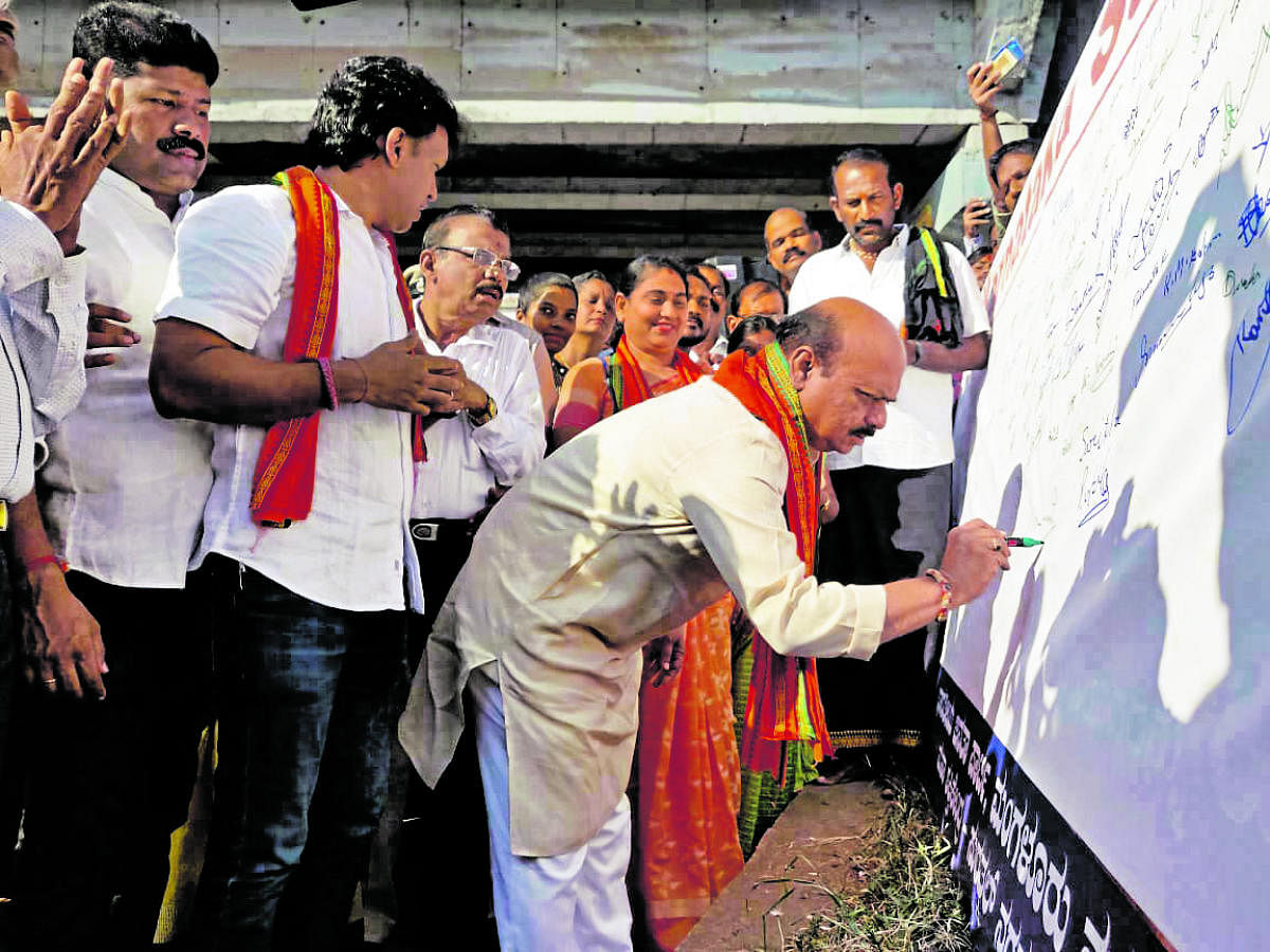 Home Minister Basavaraj Bommai takes part in a signature campaign in favour of CAA at Surathkal on Tuesday.