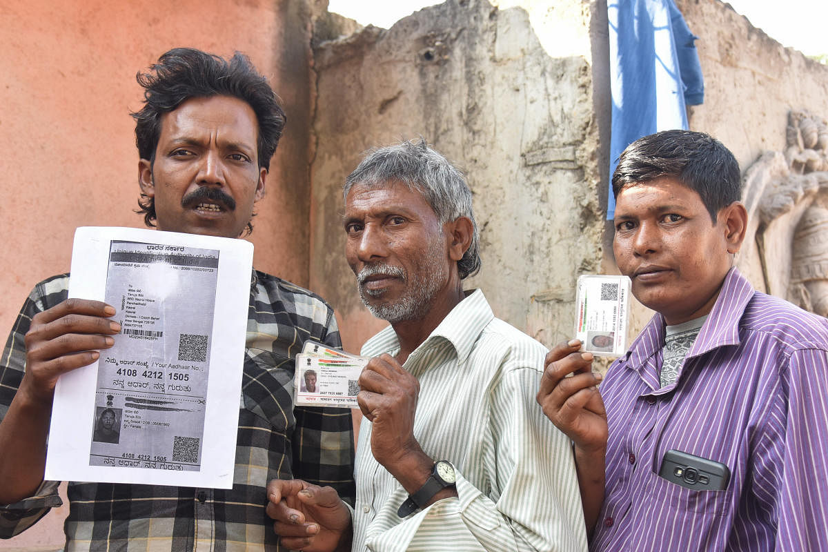 Migrant labourers show their ID cards in Kundalahalli in Bengaluru on Monday. DH Photo/SK Dinesh