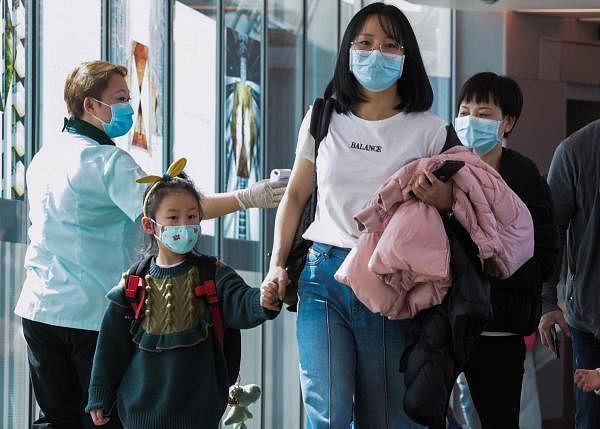 A health officer (L) screens arriving passengers from China at Changi International airport in Singapore on January 22, 2020 as authorities increased measure against coronavirus. (AFP Photo)