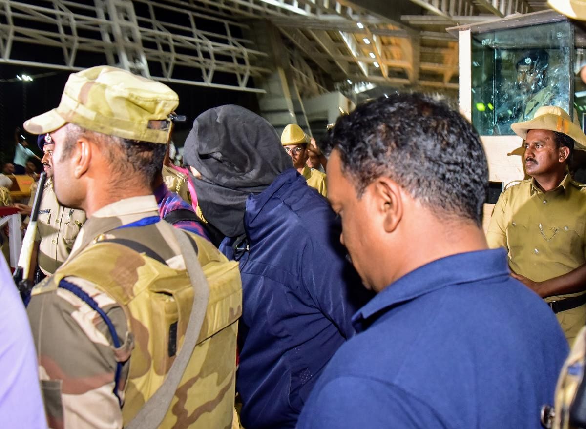 Police bring Aditya Rao (masked) to Mangaluru from Bengaluru by a flight on Wednesday.