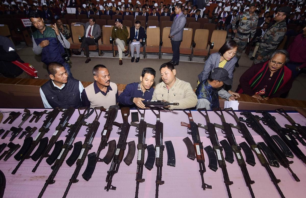 Security personnel arrange the arms and ammunitions to be put on display during the arms laying down ceremony at GMCH auditorium, in Guwahati, Thursday, Jan. 23, 2020. A total of 644 militants of eight banned insurgent outfits surrendered in Assam on Jan 23, 2020, along with 177 arms. (PTI Photo)