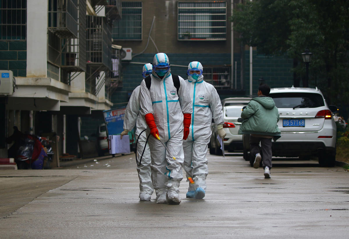 Workers from local disease control and prevention department in protective suits disinfect a residential area following the outbreak of a new coronavirus, in Ruichang, Jiangxi province, China January 25, 2020. (Reuters Photo)