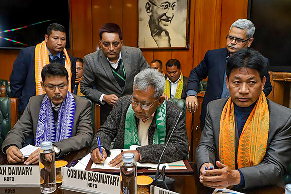 resident of National Democratic Front of Boroland (NDFB) Govinda Basumatary (C) and President of the United Bodo People's Organization (UBPO) Mihiniswar Basumatary (R) sign an accord with the Center and State government to facilitate all-round development of the Bodo areas, their language and culture without compromising the territorial integrity of Assam, in New Delhi. (PTI Photo)