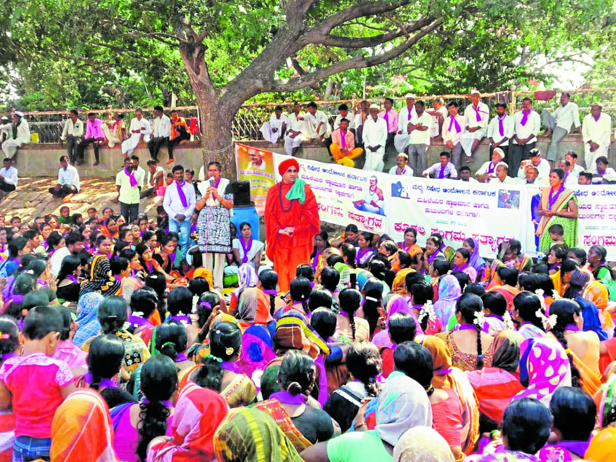 Swarna Bhat of the Rajya Madya Nishedha Andolana addresses the gathering during a protest seeking prohibition in the state, at Kudalasangama in Bagalkot district. Seer Jayamrutyunjaya Swami is seen.