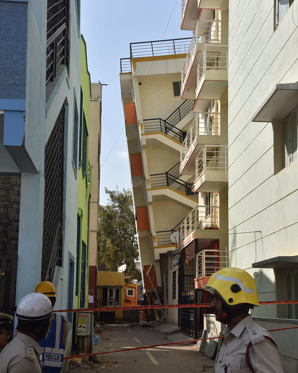 A five-storey building tilted when the adjacent site was dug up in Kempapura on Wednesday. DH Photo/Janardhan B K