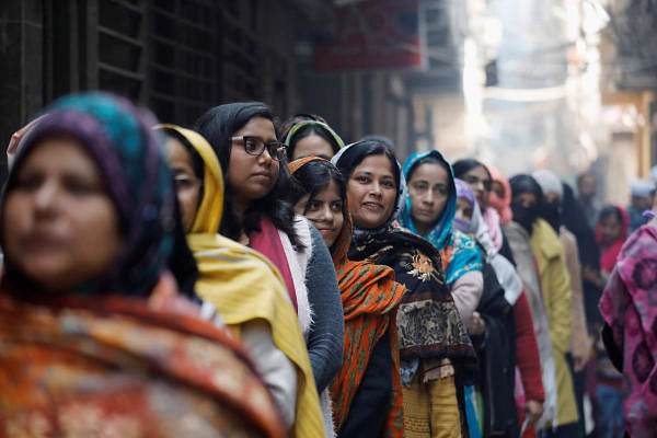 Voters stand in a queue as they wait to cast their vote outside a polling booth during the state assembly election, in Shaheen Bagh, New Delhi. (Reuters Photo)